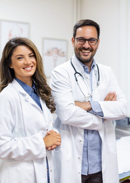 Portrait of smiling young doctors standing together. Portrait Of Medical Staff Inside Modern Hospital Smiling To Camera